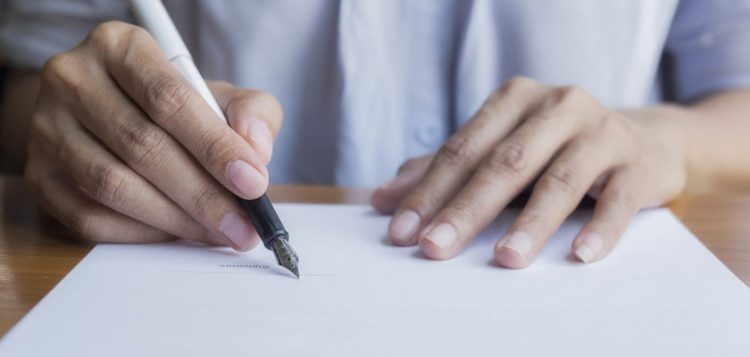 Businessperson Signing Contract,Women writing paper at the desk, man writing with pen and reading books at table,man Signing, Contract, Form. in office ,morning light ,selective focus. 
