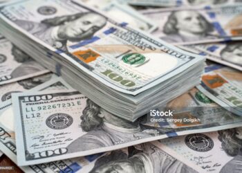 Stack of one hundred dollars notes on dollars background