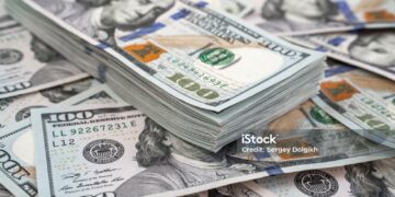 Stack of one hundred dollars notes on dollars background