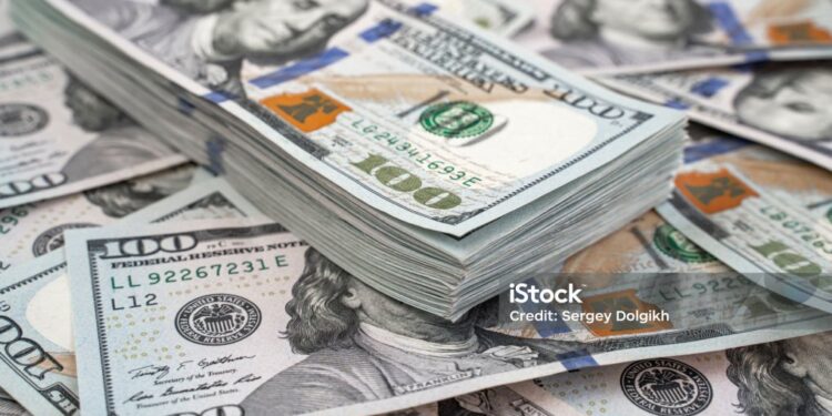 Stack of one hundred dollars notes on dollars background