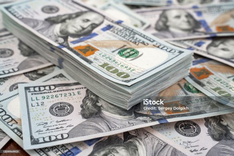 Stack of one hundred dollars notes on dollars background